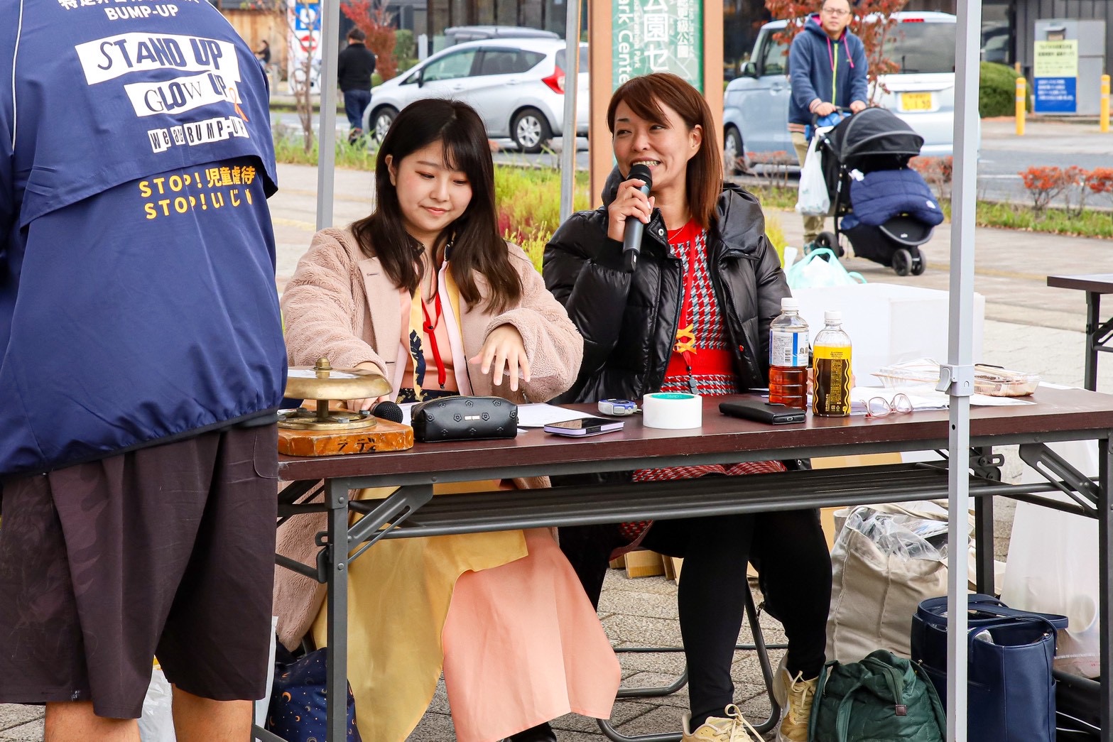 屋外イベントでマイクを使って進行する様子